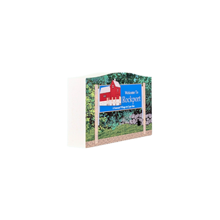 3/4" thick wooden replica with an illustration of a 'Welcome To Rockport' design with a red house, blue banner, green foliage, and a stone wall, shown on a plain white background.