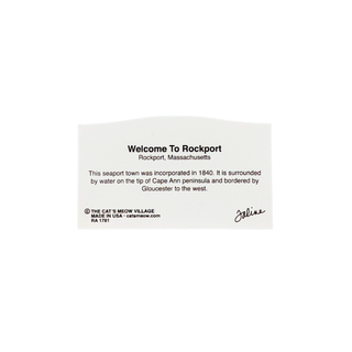back of product featuring black text that reads 'Welcome To Rockport Rockport, Massachusetts' along with a short historical paragraph, a small 'The Cat's Meow Village' mark, and a signature on a plain white background.