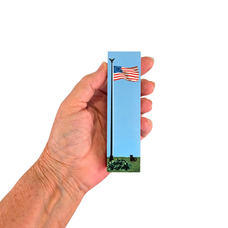 3/4" thick wooden replica with an illustration of an American flag on a pole against a blue sky, with grass and small dark objects at the bottom, on a plain white background.