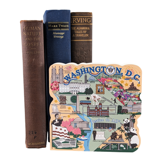 Three books stacked with a colorful  3/4" thick wooden model of Washington D.C. on a white background