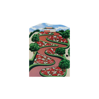 3/4" thick wooden Garden design with flower beds, pathways, and a building in the background.