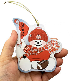 ornament with cartoon character in red and white attire, held by a hand.