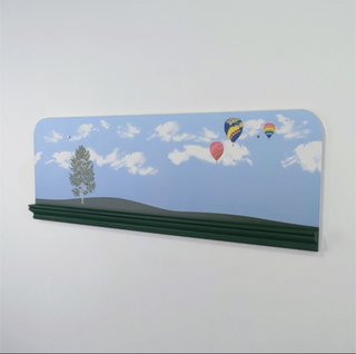Decorative shelf with a scenic design of hot air balloons and a tree on a blue sky background.