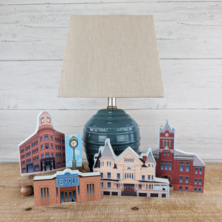 Decorative lamp with paper cityscape models on a wooden surface