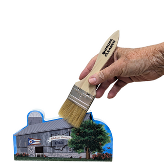 Hand holding a paintbrush labeled 'House Cleaner' over a cutout of a barn scene.