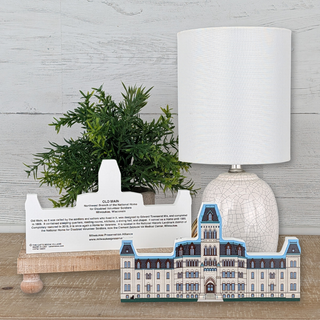 wooden Model of Old Main National Home for disabled volunteer soldiers in milwaukee wisconsin  on a wooden surface with a lamp and plant in the background.
