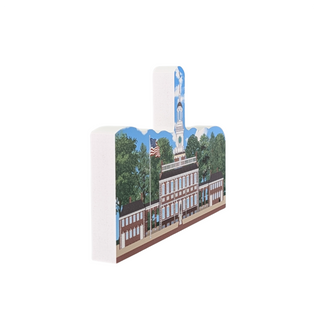 3/4" thick wooden cutout  of a building with a clock tower and American flag on a white background
