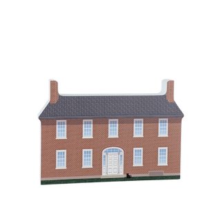 3/4" thick wooden cutout of a brick house with white windows and door on a white background