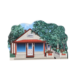 Wooden replica of a house with trees and a clear sky