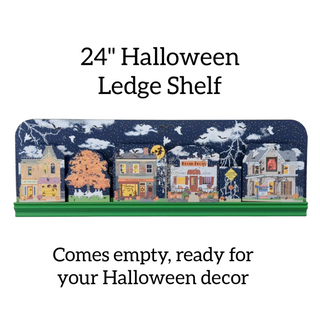 Halloween-themed ledge shelf with decorative houses and text on a white background