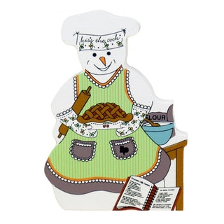 3/4" thick wooden replica with an Illustration of a snowman a baking theme. The snowman wears a white chef's hat with the words 'keep the cook!', a light green apron with floral trim, and is holding a brown pie or apple crumble.