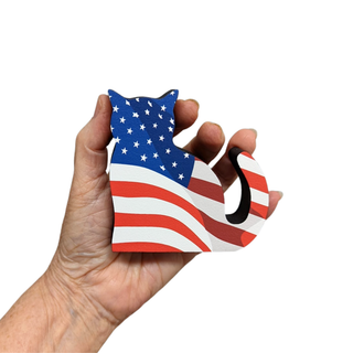 hand holding 3/4" thick wooden cat cutout with American flag printed on it for home decor