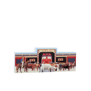 3/4" thick wooden cutout  of a stockyard scene with a horse, cowboys, and longhorn cattle in front of a red building.