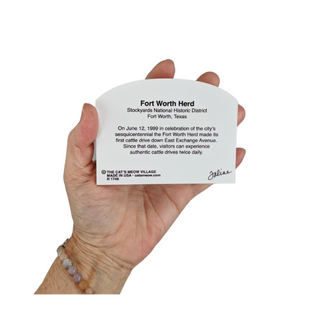 Hand holding a 3/4" thick wooden cutout  with Fort Worth Herd information against a white background