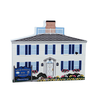 Wooden replica of a building with a sign for 'Wequassett Inn' with flowers 