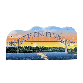 Wooden replica of a Bridge over water with a sunset sky and trees in the background