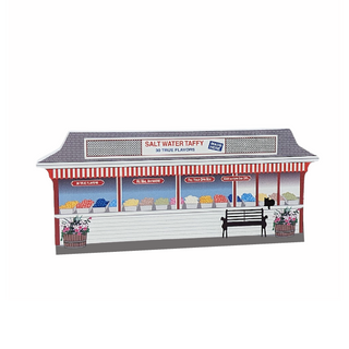 Wooden Model of a taffy stand with colorful displays and a bench on a white background