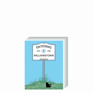 Wooden 3/4" Replica with a sign, featuring text and a logo, against a blue sky and grass background.