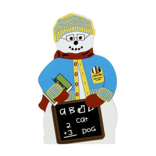 3/4" thick wooden replica with an Illustration of a snowman holding a small chalkboard with simple equations and the word 'DOG'. The snowman wears a yellow knit hat, blue sweater with yellow buttons, red scarf, and brown mittens, and has a badge that says 'Crayons'.